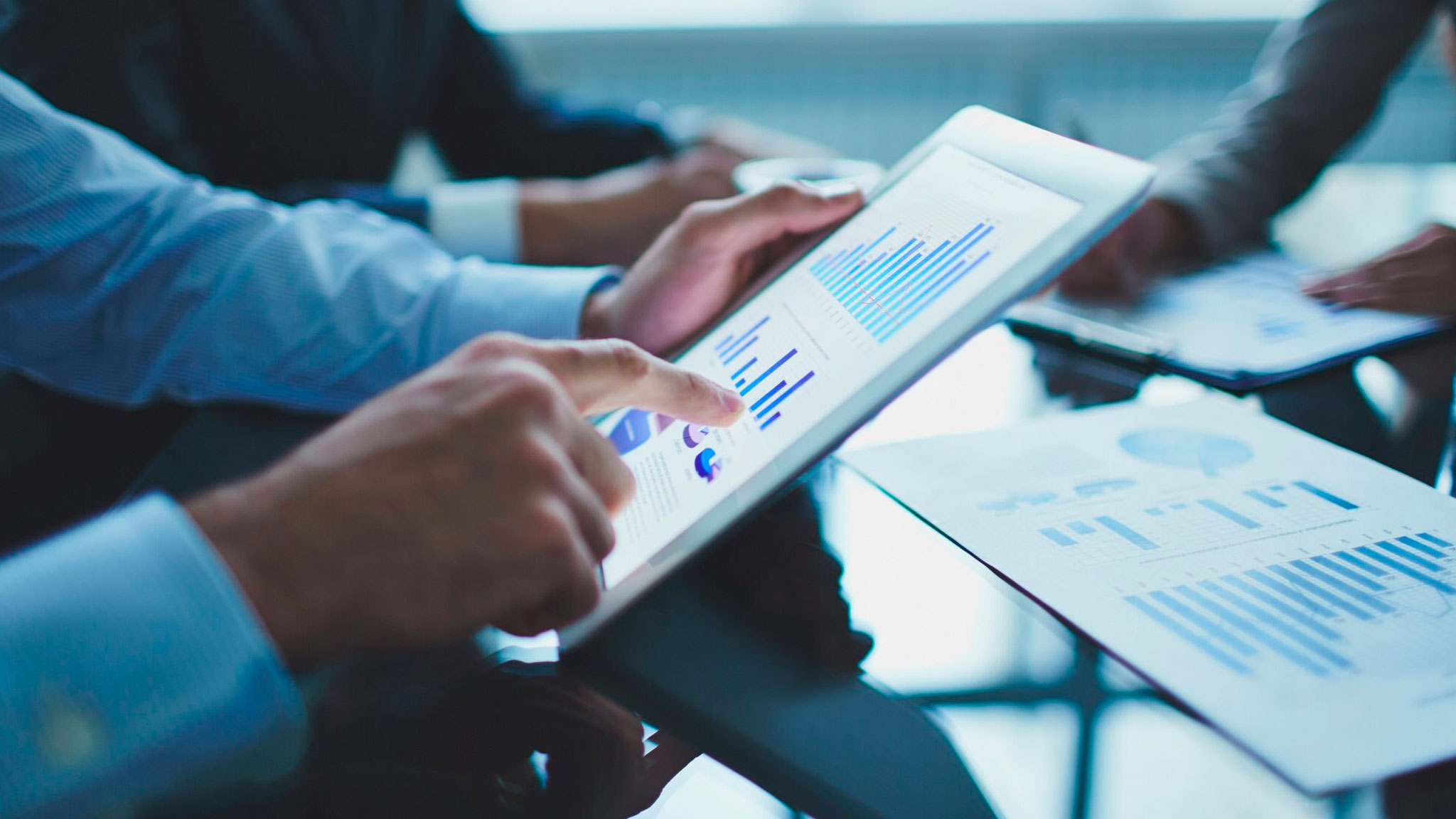 Gráfico financiero y lupa representando servicios de auditorías y análisis financiero detallado.